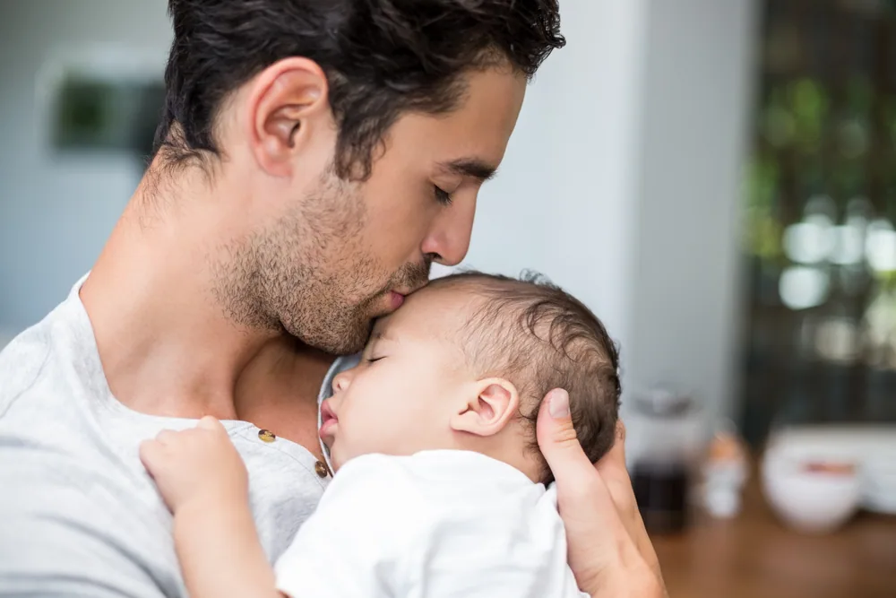 Vater mit schlafendem Baby auf dem Arm
